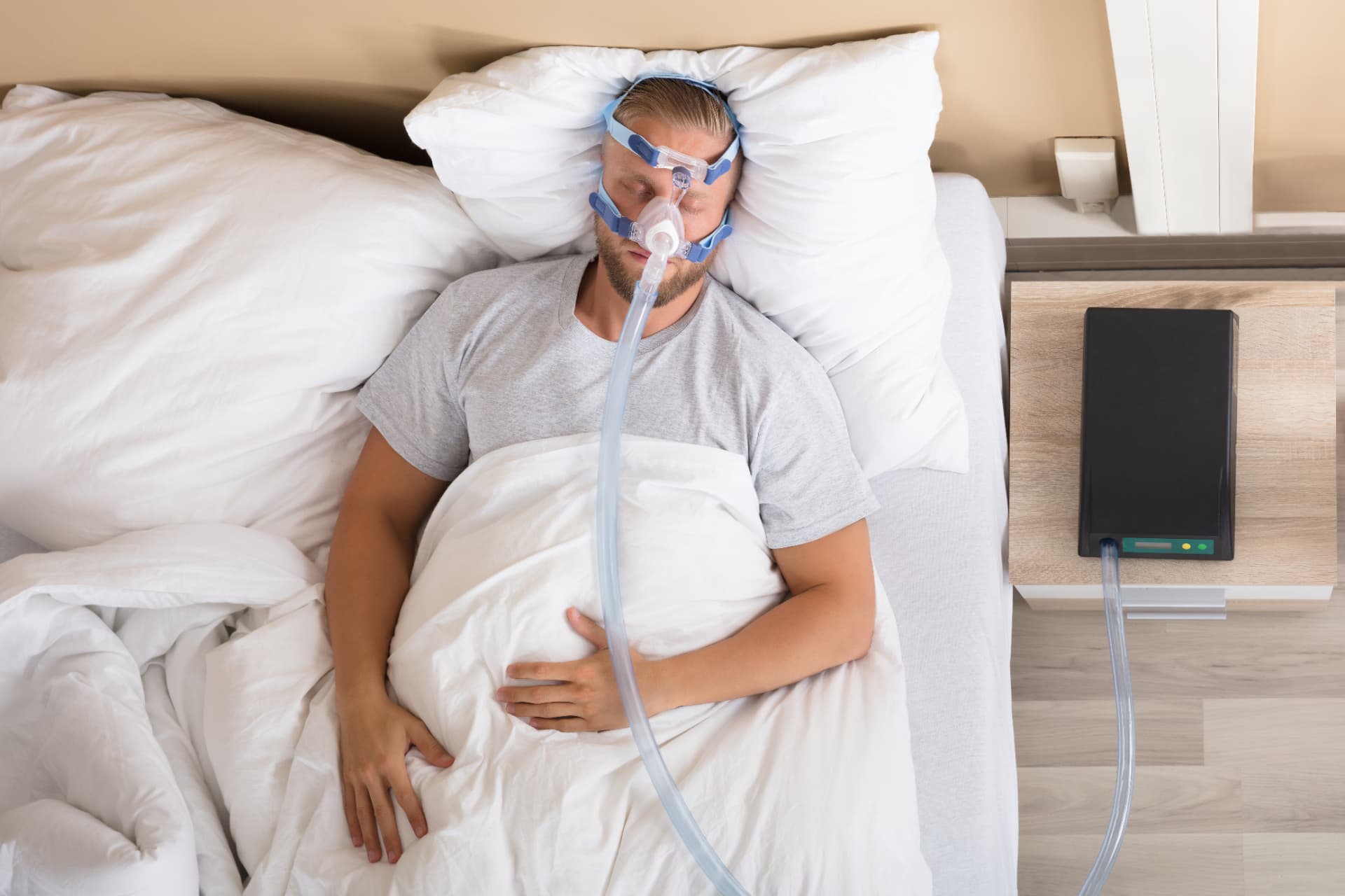 Man sleeping in bed with a CPAP machine for sleep apnea